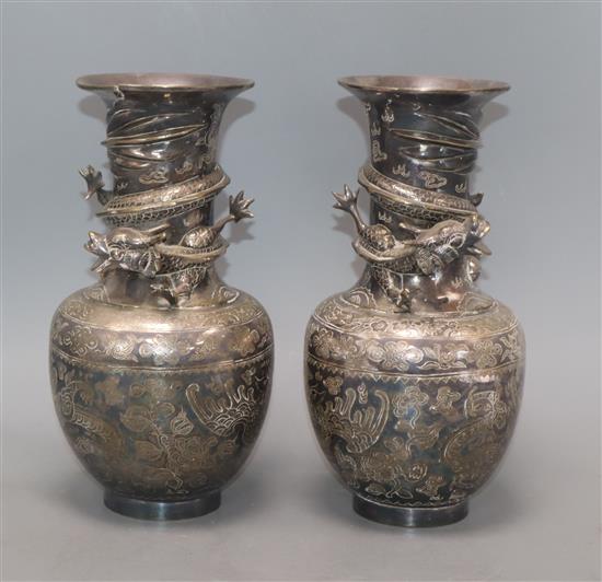 A pair of Japanese silver-plated bronze vases engraved and applied with dragons (one rim a.f.) height 25cm